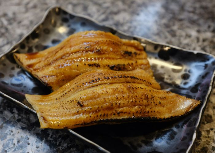 Grilled anago conger eel on a serving tray,