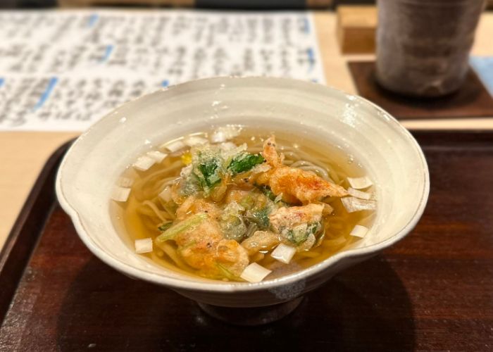 Seafood tempura in a bowl of broth and noodles, served on a dark tray at Mirei.
