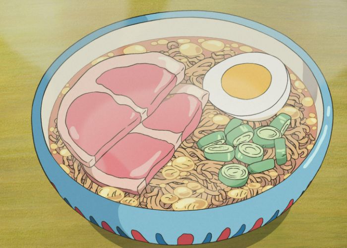 A steaming bowl of ramen from Ponyo, with cooked ham, a soft-boiled egg, and spring onions.