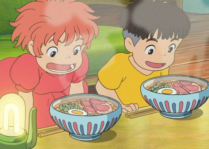 Ponyo and Sosuke in awe of their steaming bowls of ramen, sitting on the floor next to a low table.