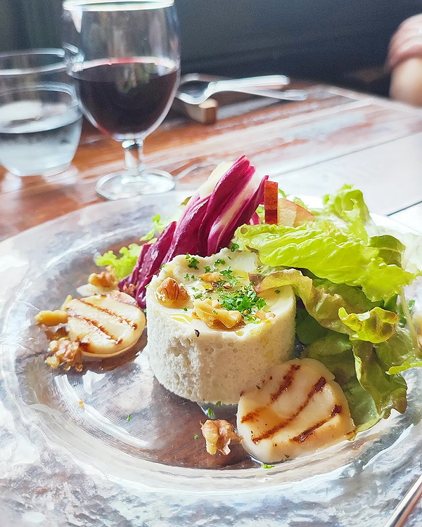 Gourmet dish with cheese mousse and salad in elegant restaurant setting