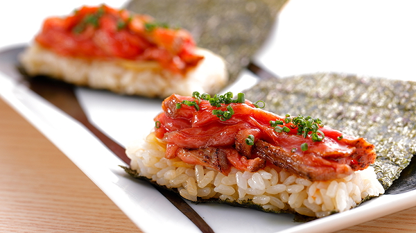 Delicious sushi served on nori with a topping of fresh fish and chives