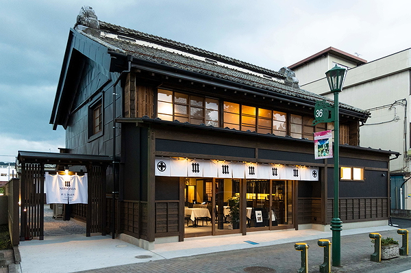 Traditional Japanese restaurant exterior with wooden architecture at dusk