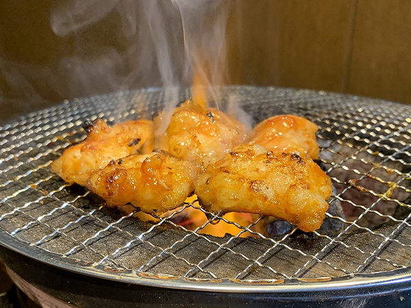 Grilled chicken sizzling on a barbecue at a popular restaurant