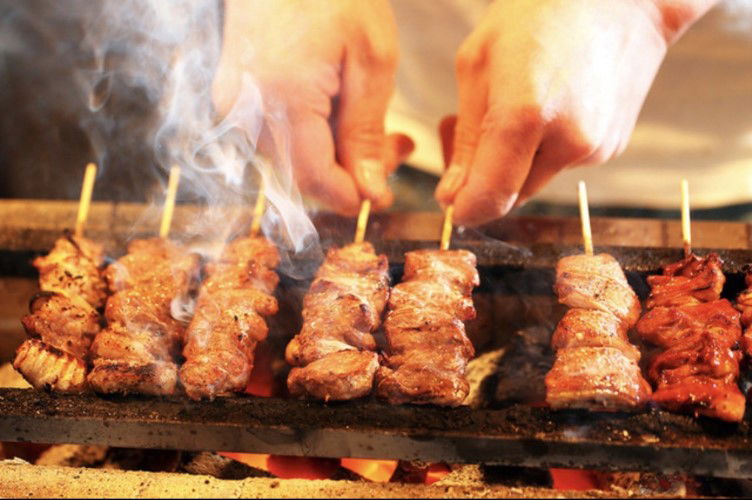 motsuyaki skewers grilled over charcoal