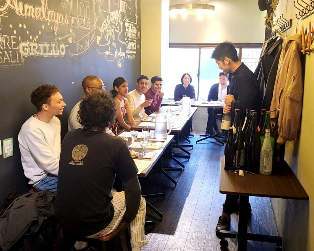 A group of guests listening to a sake expert at this Shibuya sake tasting.