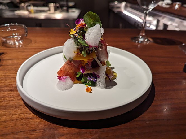 Elegant gourmet dish with colorful garnishes on a white plate at restaurant