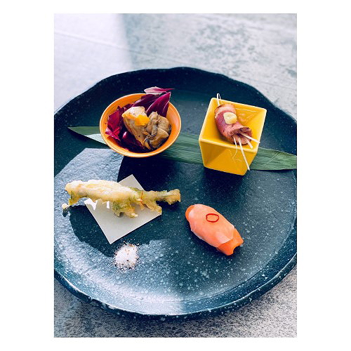 Gourmet dishes beautifully presented on a dark ceramic plate