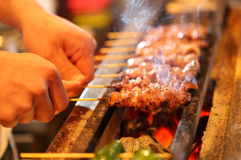Grilled skewers being prepared over open flames, showcasing BBQ cooking.