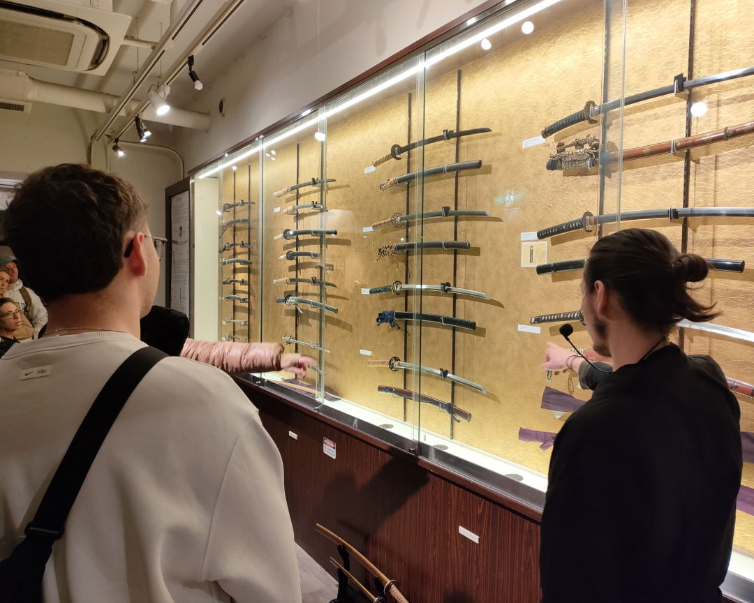 A guide showing many Japanese samurai swords at the Samurai and Ninja Museum in Kyoto