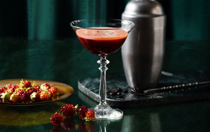 An elegant red cocktail at THE 5th by SUMADORI-BAR, surrounded by berries and a cocktail shaker.