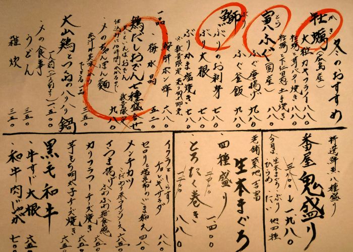 A hard-to-read Japanese menu showing handwritten kanji and red scrawls.