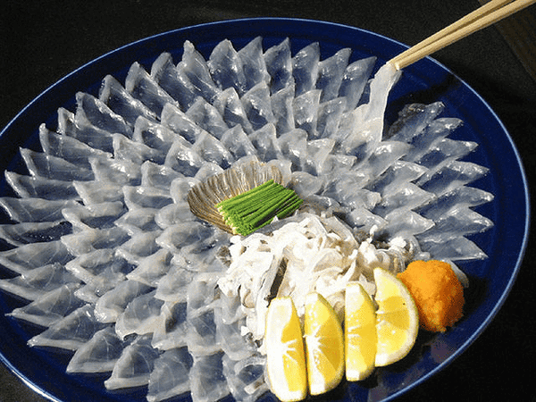 Elegantly plated sashimi with lemon slices and garnish