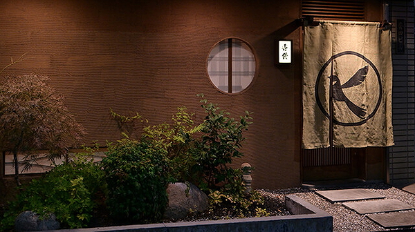 Cozy Japanese restaurant entrance at night with traditional decor