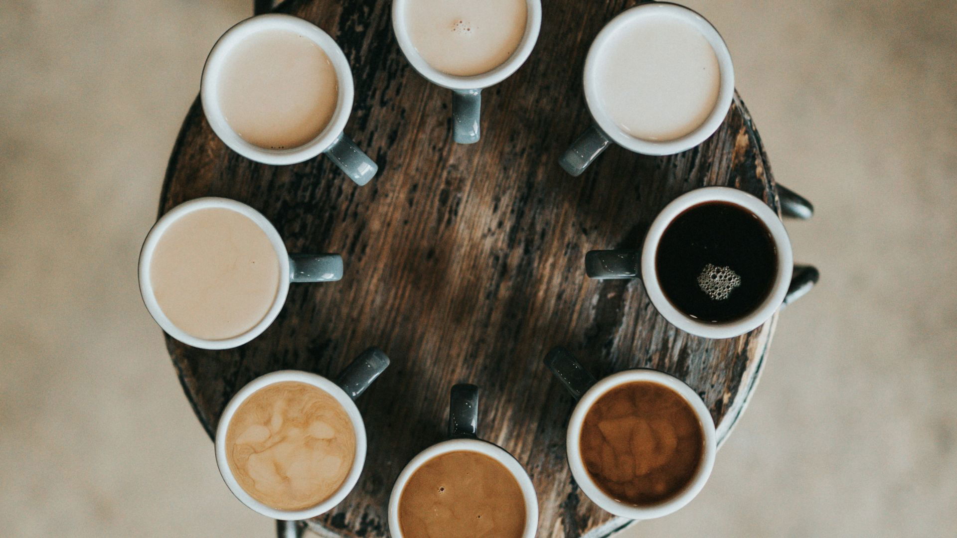 Variety of coffee cups arranged on a rustic table
