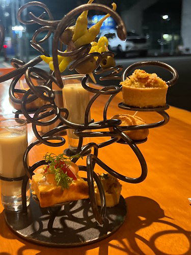 Gourmet appetizers elegantly displayed on artistic metal stand
