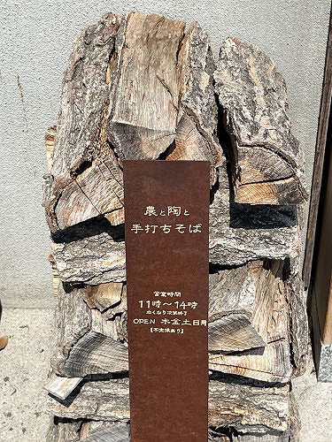 Stacked firewood outside a rustic Japanese soba restaurant