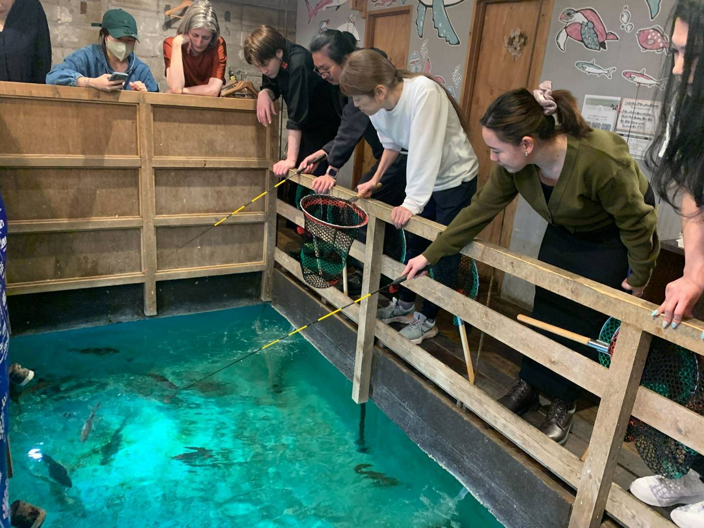 People fishing for their dinner at an indoor pond, courtesy of a unique Shibuya tour.