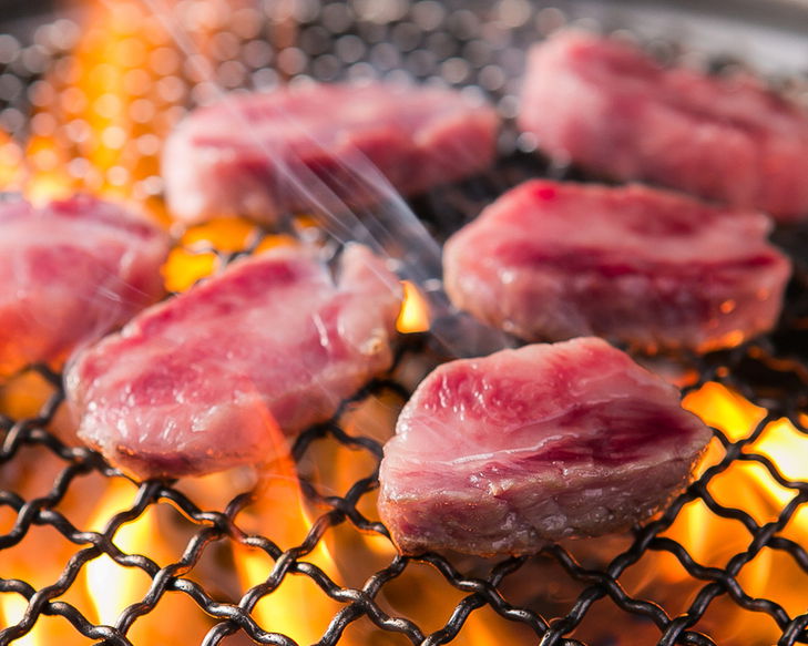 Bite-sized pieces of wagyu beef being grilled over flames at Yakiniku Lee-en Nakano.