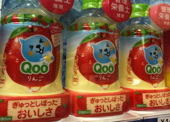 Bottles of apple-flavored Qoo! lined up in a vending machine. 