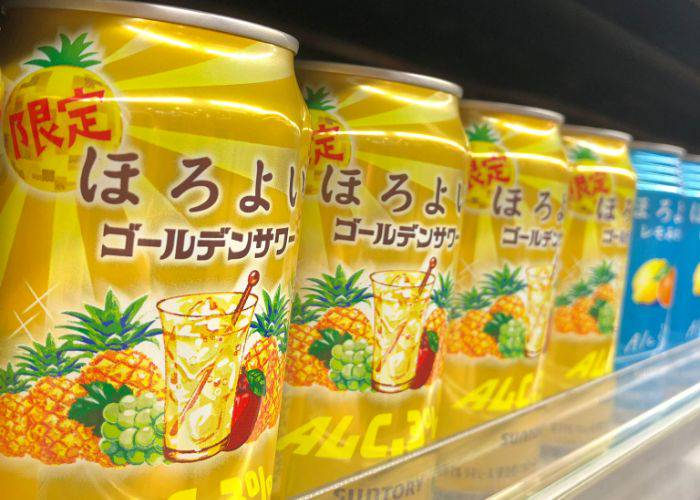A limited-edition Horoyoi with a golden design, covered in pineapples, apples, and grapes. "Golden Sour" flavor is written on the front.