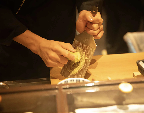 Chef grating fresh wasabi in gourmet Japanese restaurant