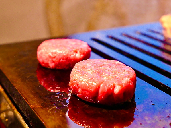 Juicy burger patties sizzling on a hot grill