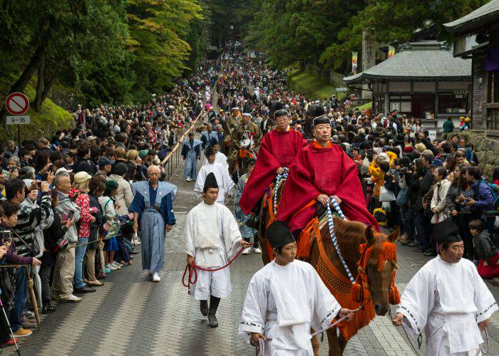 Proud samurai in red cloaks ride horses through the Nikko Toshogu Shuki Taisai Grand Autumn Festival in Tochigi.