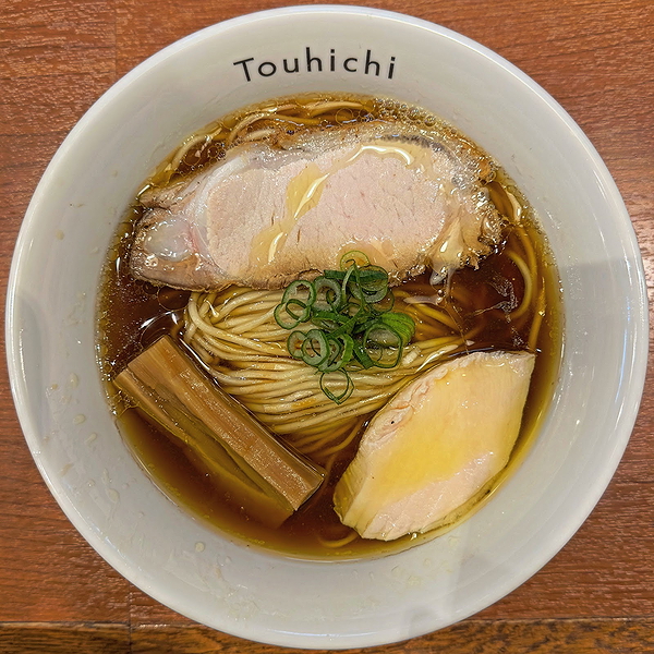 Delicious ramen bowl with sliced pork, scallions, and noodles