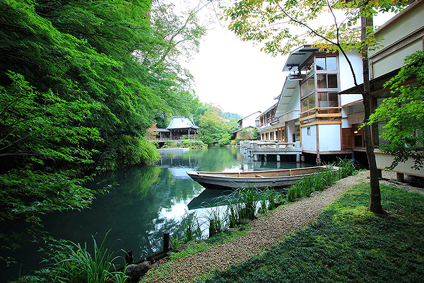 Scenic riverside restaurant with lush greenery and traditional architecture.