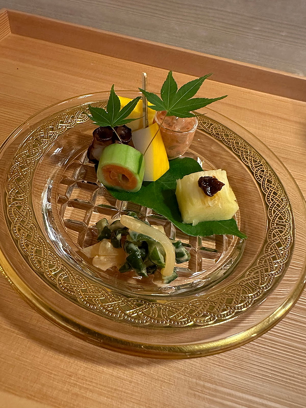 Elegant Japanese appetizer platter with assorted delicacies on a glass plate