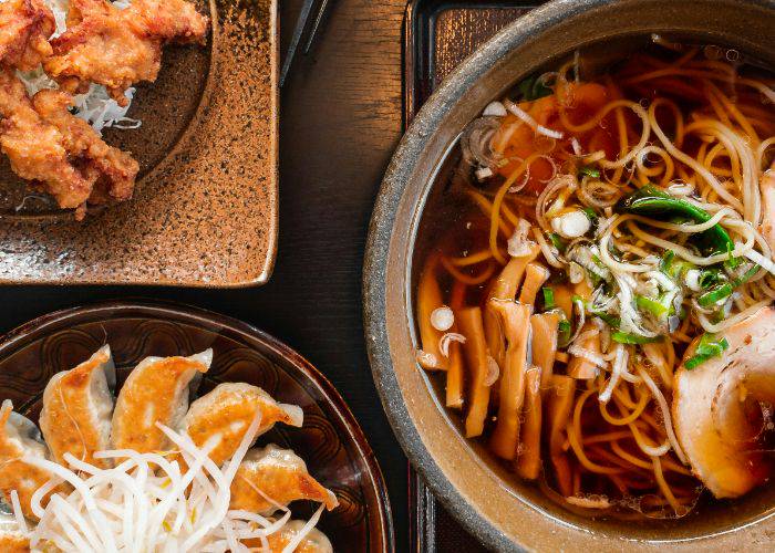 A top-down shot of Japanese food: ramen, gyoza and karaage fried chicken.