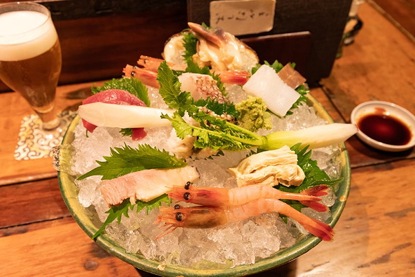 Fresh seafood platter with shrimp and assorted garnishes on ice at a restaurant