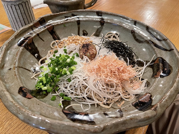 Artisan noodle dish with fresh toppings in ceramic bowl