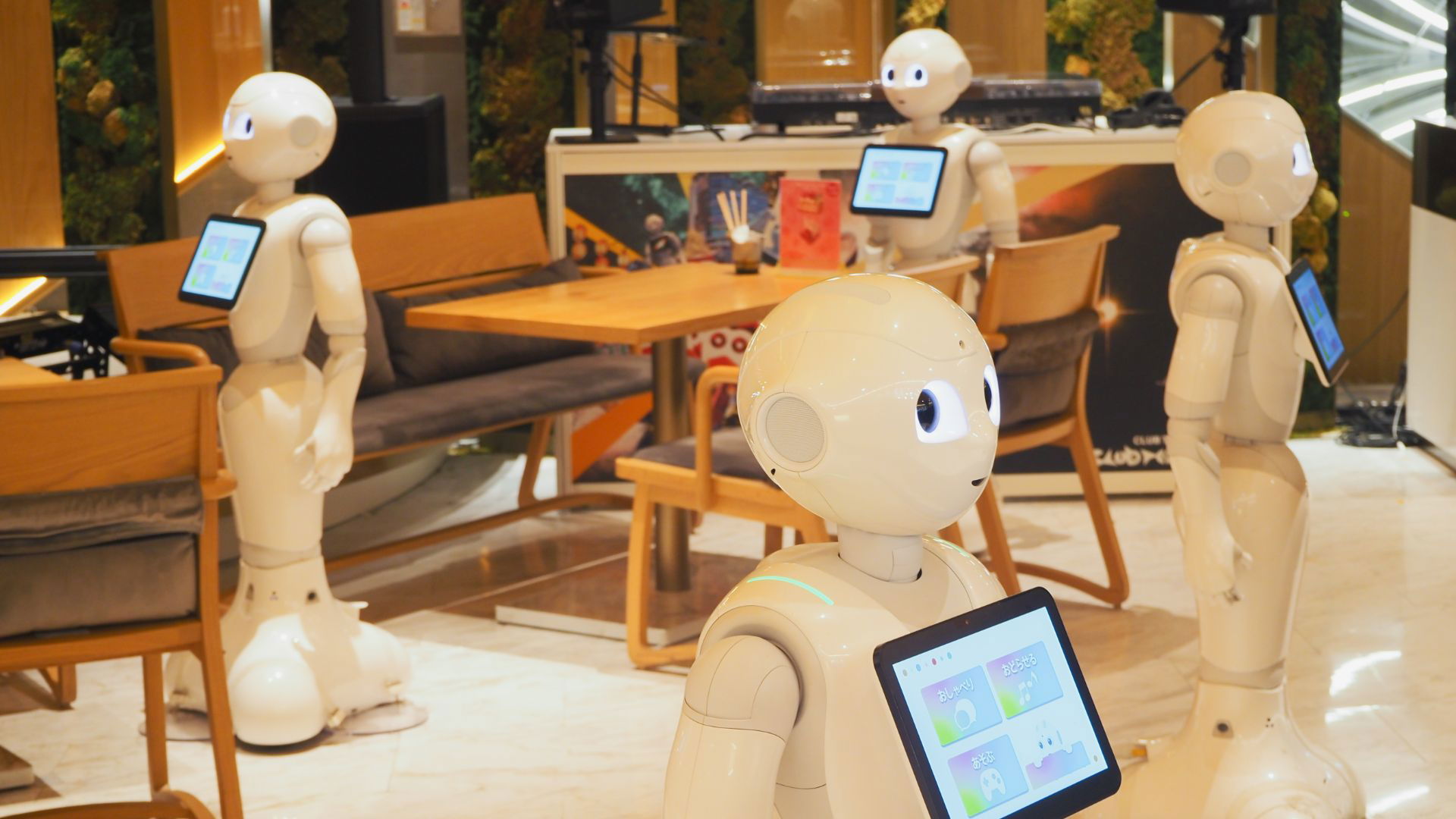 Robots with tablets in modern cafe setting