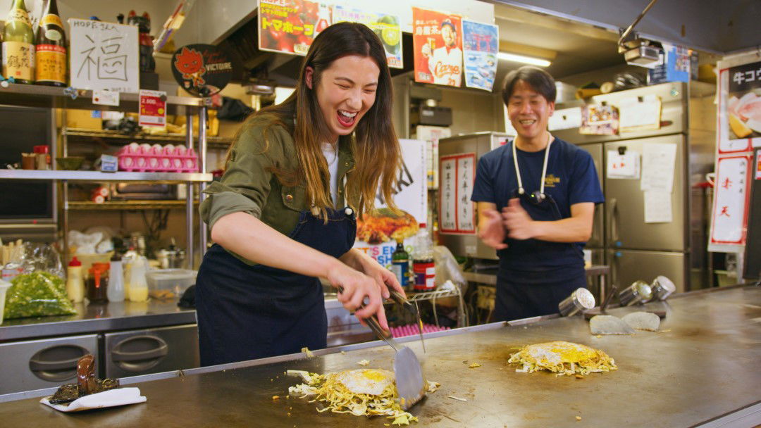 Shizuka from byFood happily making her own okonomiyaki at a restaurant in Hiroshima