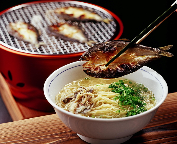 Delicious ramen bowl with grilled fish and fresh green onions