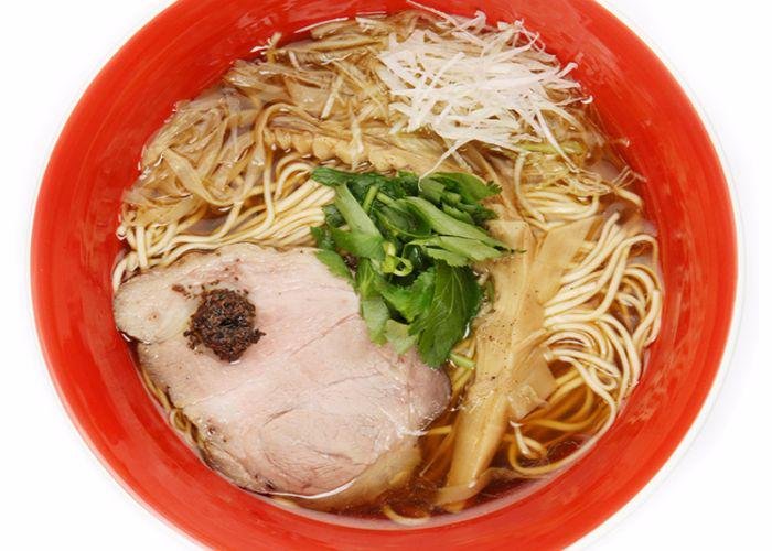 Shoyu Ramen at Tsuta, a Michelin-starred ramen restaurant in Tokyo. Red bowl with a thick slice of chashu pork and straight ramen noodles.