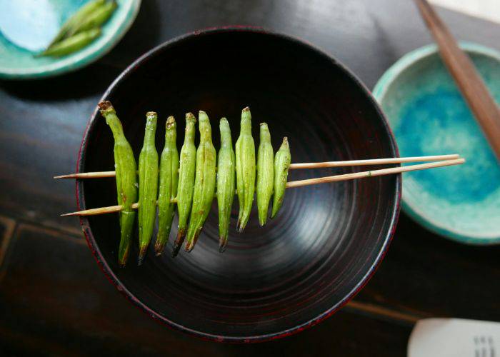 A selection of skewered lily buds resting on a bowl, arranged by size.