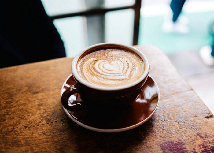 A coffee with a foam art, looking like a leaf.