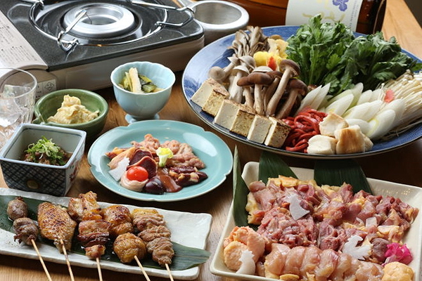 Assorted Japanese dishes with skewers, vegetables, and hot pot setup
