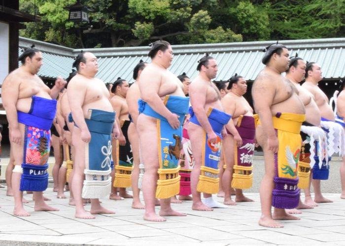 Sumo wrestlers lined up outside, getting ready for their tournament