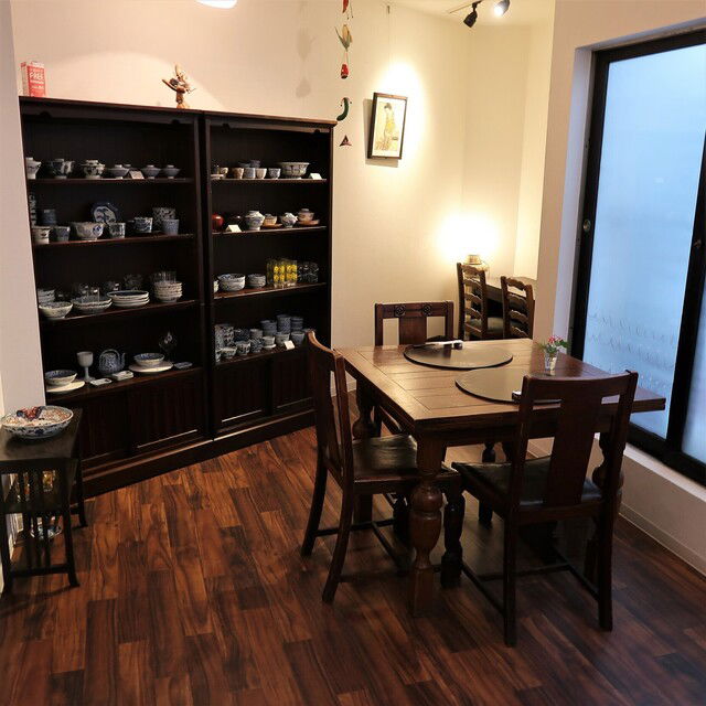 The dining area of Kashiwai, set against a display cabinet of dishes.