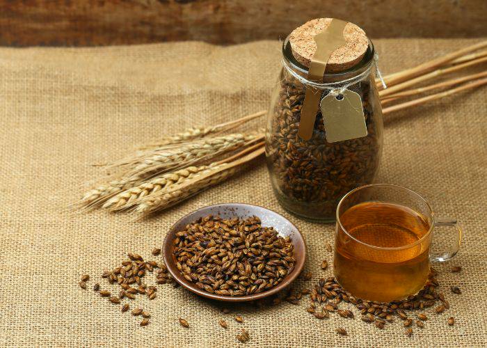 Mugicha with a jar and plate of raw barley grains.