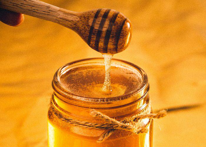 A jar of honey with a thin rope tied around it for a homely feel.