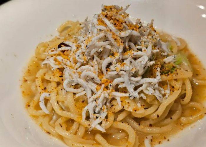 A saucy plating of pasta at Macauda, garnished with shirasu whitebait fish.