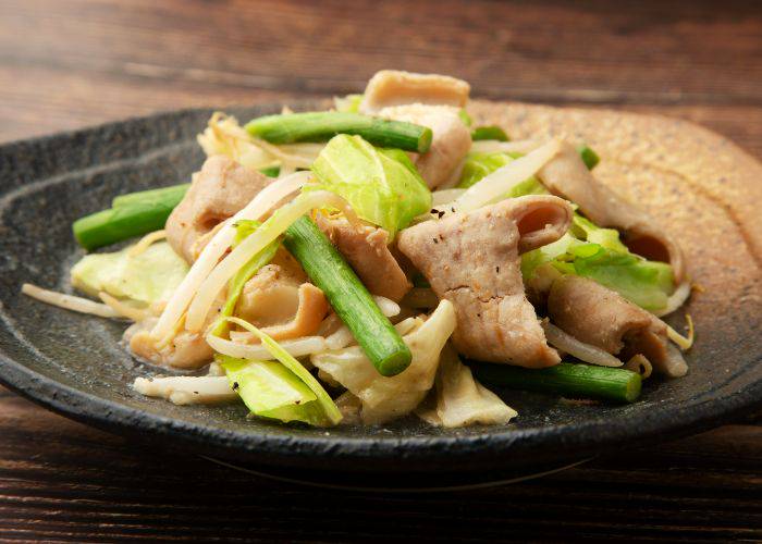 A serving of horumon; grilled offal meats served with green beans, cabbage and bean sprouts.