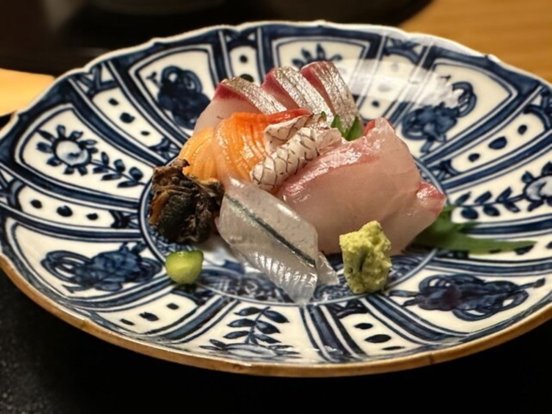 A serving of diverse sashimi at Okada, served in a traditional bowl.