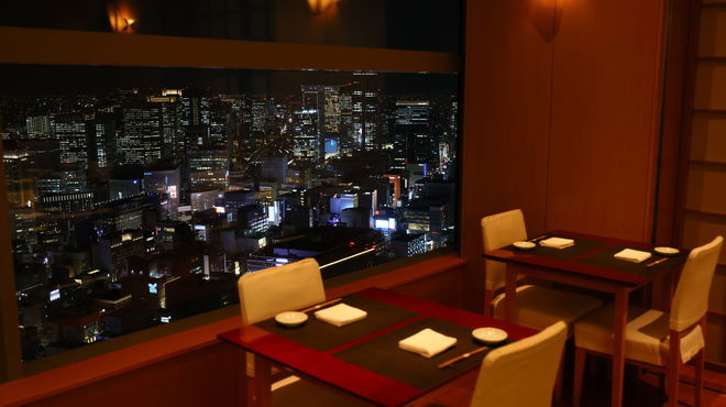 The two-seater tables of Sushi Misuji Caretta Shiodome, looking out over the Tokyo skyline.