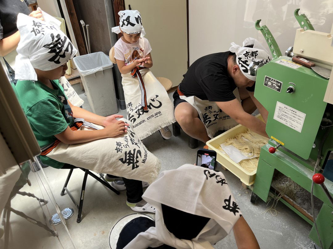 People using the ramen noodle-making machine in this unique Kyoto cooking class.